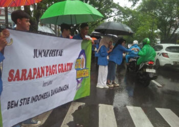 BAGI NASI BUNGKUS - Baksos, puluhan  mahasiswa dan mahasiswi STIE Indonesia Banjarmasin berbagi nasi bungkus di jalan raya dan sembako di Panti Asuhan Yayasan Insanul Kamil (Yainkam), Jumat (1/3).