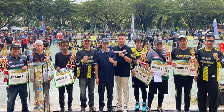 SEKDA Kabupaten Tapin Dr H Sufiansyah MAP didampingi Asmintum H Fiqri Irmawan SSTP saat menyerahkan trophy juara kepada para pemenang lomba ketangkasan Damkar se-Kalsel.
