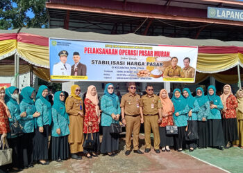 PJ Bupati Tapin M Syarifuddin MPd bersama Ketua TP PKK Masrupah berfoto bersama pada kegiatan pasar murah jelang Bulan Ramadhan yang dilaksanakan dinas perdagangan setempat di Kecamatan Tapin Utara.