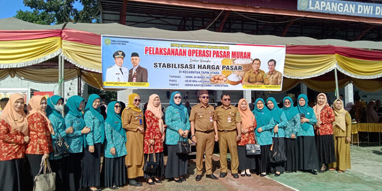PJ Bupati Tapin M Syarifuddin MPd bersama Ketua TP PKK Masrupah berfoto bersama pada kegiatan pasar murah jelang Bulan Ramadhan yang dilaksanakan dinas perdagangan setempat di Kecamatan Tapin Utara.