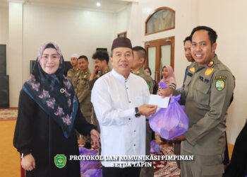 PJ Bupati Tapin M Syarifuddin MPd dan istri saat membagikan paket Ramadhan ke PTT Satpol-PP Kabupaten Tapin.