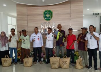 PJ Bupati Tapin M Syarifuddin bersama Plt Kadinsos Syafrudin saat menyerahkan bantuan sembako dari Dinsos Kalsel untuk masyarakat miskin di Kkabupaten Tapin, Rabu (13/3).