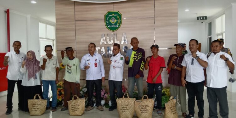 PJ Bupati Tapin M Syarifuddin bersama Plt Kadinsos Syafrudin saat menyerahkan bantuan sembako dari Dinsos Kalsel untuk masyarakat miskin di Kkabupaten Tapin, Rabu (13/3).