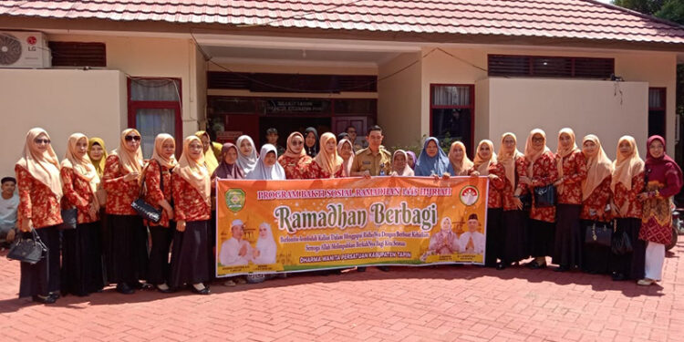 KETUA DWP Tapin Hj Mashuriyah berfoto bersama Camat Piani Arie Wijaya dan muspika kecamatan saat menyerahkan bantuan sembako untuk masyarakat tidak mampu, Senin (25/3).