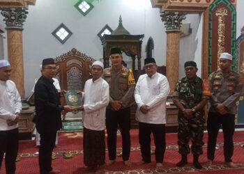 PJ Bupati Tapin M Syarifuddin didampingi Kapolres Tapin AKBP Sugeng Priyanto SIK saat menyerahkan 40 buah mushaf Al-Qur'an untuk mesjid setempat dan Ponpes Darul Muhibien Kecamatan Binuang.