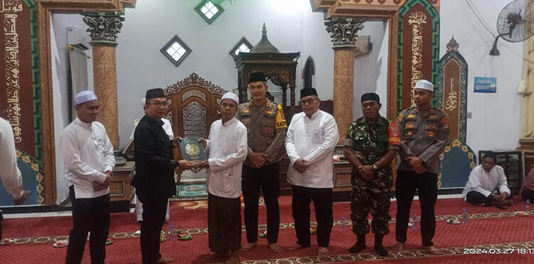 PJ Bupati Tapin M Syarifuddin didampingi Kapolres Tapin AKBP Sugeng Priyanto SIK saat menyerahkan 40 buah mushaf Al-Qur'an untuk mesjid setempat dan Ponpes Darul Muhibien Kecamatan Binuang.