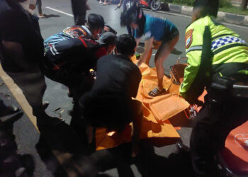 WARGA dan anggota emergency saat mengevakuasi korban ke mobil ambulan.