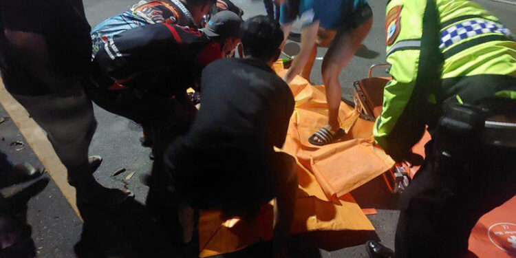 WARGA dan anggota emergency saat mengevakuasi korban ke mobil ambulan.