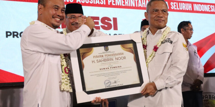 Kepala Dinas Pemberdayaan Masyarakat dan Desa Provinsi Kalimantan Selatan, Faried Fakhmansyah saat menerimakan penghargaan Gubernur Kalsel, H Sahbirin Noor sebagai Dewan Pembina Apdesi Provinsi Kalsel dari Ketua Umum Apdesi, Surta Wijaya.