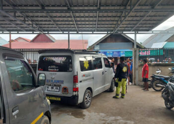 Polisi dibantu emergecy saat evakuasi jasad korban ke mobil ambulan .