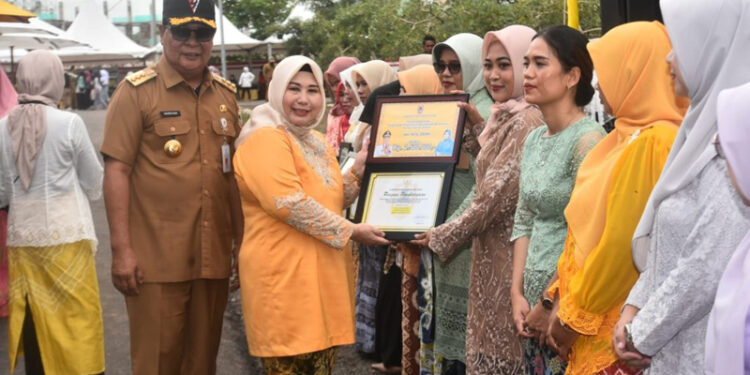 Ketua Tim Penggerak PKK Provinsi Kalimantan Selatan, Hj Raudatul Jannah, SKM, MKes atau Acil Odah didampingi Gubernur Kalsel, H Sahbirin Noor saat menyerahkan kepada perempuan berjasa dan berprestasi di banua.