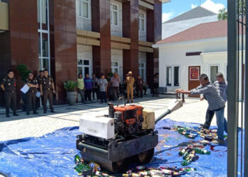 MUSNAHKAN - Kajari Tapin Adi Fakhrudin SH MH beserta jajaran saat menyaksikan pemusnahan barang bukti minuman keras di halaman kantor kejari setempat, Selasa (2/4).