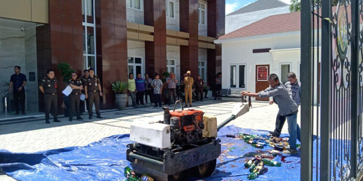 MUSNAHKAN - Kajari Tapin Adi Fakhrudin SH MH beserta jajaran saat menyaksikan pemusnahan barang bukti minuman keras di halaman kantor kejari setempat, Selasa (2/4).