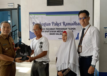 PJ Bupati Tapin M Syarifuddin MPd saat menyerahkan secara simbolis bantuan paket ramadhan kepada pensiunan ASN yang menjadi nasabah Bank Kalsel, Senin (1/4).