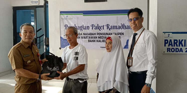 PJ Bupati Tapin M Syarifuddin MPd saat menyerahkan secara simbolis bantuan paket ramadhan kepada pensiunan ASN yang menjadi nasabah Bank Kalsel, Senin (1/4).
