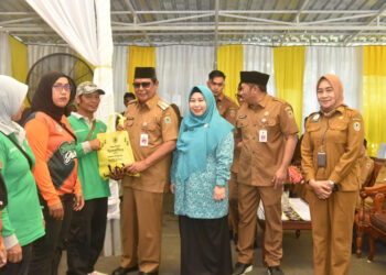 GUBERNUR Paman Birin didampingi Ketua PKK Kalsel Hj Raudatul Jannah atau Acil Odah membagikan paket berisi ikan secara gratis kepada warga