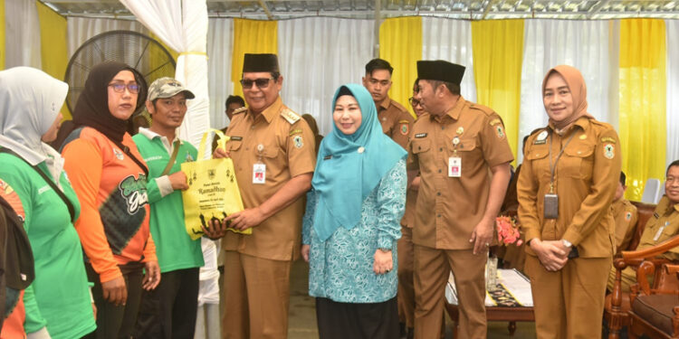 GUBERNUR Paman Birin didampingi Ketua PKK Kalsel Hj Raudatul Jannah atau Acil Odah membagikan paket berisi ikan secara gratis kepada warga