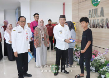 PJ Bupati Tapin M Syarifuddin MPd bersama Plt Kepala Dinas Sosial H Syafrudin SIP saat menyerahkan bantuan sosial untuk anak yatim piatu di Aula Tamasa, Rabu (3/4).