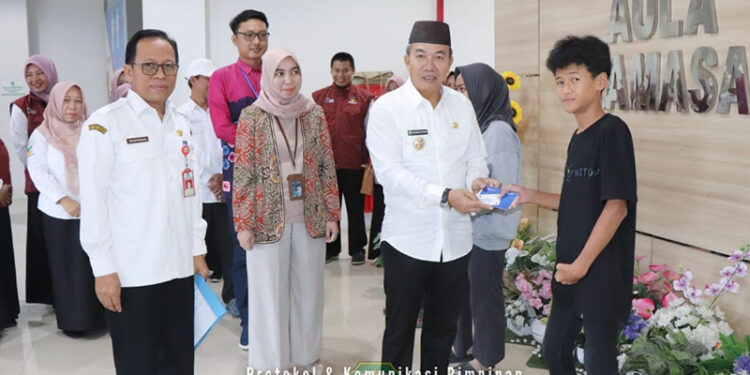 PJ Bupati Tapin M Syarifuddin MPd bersama Plt Kepala Dinas Sosial H Syafrudin SIP saat menyerahkan bantuan sosial untuk anak yatim piatu di Aula Tamasa, Rabu (3/4).