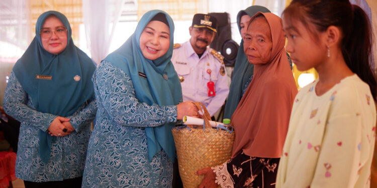 KETUA TP PKK Kalsel Hj Raudatul Jannah atau Acil Odah didampingi Pj Bupati Tala Syamsir Rahman menyerahkan bantuan kepada warga di Kecamatan Tambang Ulang. 