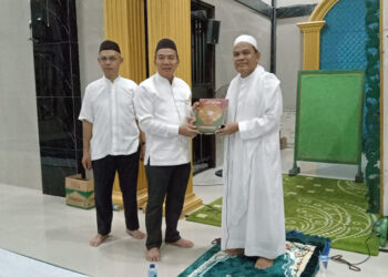 PJ Bupati Tapin M Syarifuddin bersama Sekda H Sufiansyah saat menyerahkan bantuan Alquran untuk masjid Baitun Nur yang diterima Guru H Muhammad Yunus.