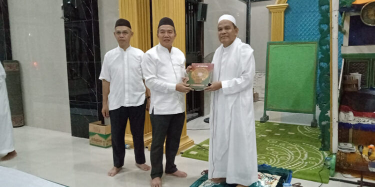 PJ Bupati Tapin M Syarifuddin bersama Sekda H Sufiansyah saat menyerahkan bantuan Alquran untuk masjid Baitun Nur yang diterima Guru H Muhammad Yunus.