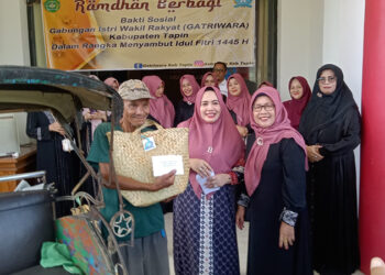 KETUA Gatriwara Tapin Hj Faridah Yamani saat membagikan bantuan paket ramadhan untuk penarik becak di Tapin.
