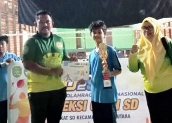KETUA panitia lomba I Made Alit Saputra saat menyerahkan trophy juara I O2SN putra dari SDN Rantau Kiwa 1.