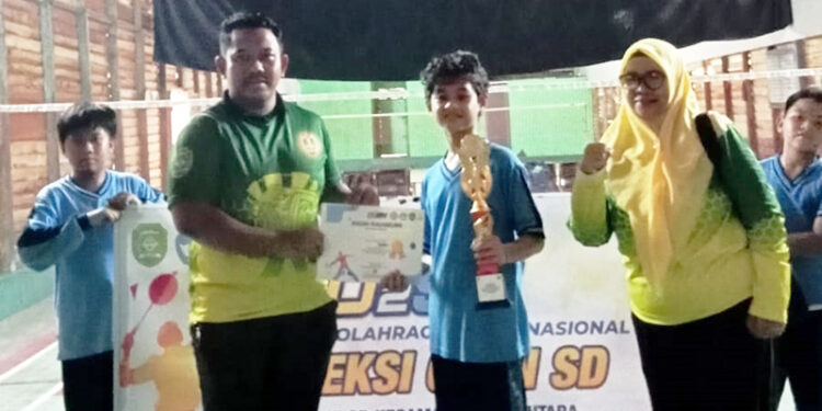 KETUA panitia lomba I Made Alit Saputra saat menyerahkan trophy juara I O2SN putra dari SDN Rantau Kiwa 1.