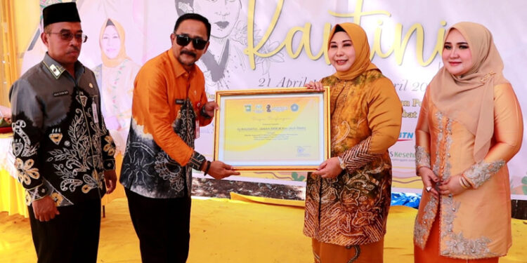 PJ Bupati Tanah Laut Syamsir Rahman menyampaikan penghargaan sebagai Wanita Inspiratif Banua kepada Hj Raudatul Jannah Sahbirin Noor atau Acil Odah pada peringatan Hari Kartini di Pelaihari. 
