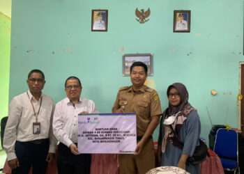 DIREKTUR UPZ Bank Kalsel H Muhammad Fajri Muhtadi saat menyerahkan bantuan kepada Lurah Kuripan Yoyok Hardiyanto didampingi perwakilan korban kebakaran Dewi Nurdiani Rahmi.