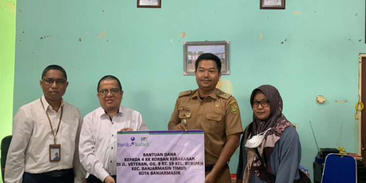 DIREKTUR UPZ Bank Kalsel H Muhammad Fajri Muhtadi saat menyerahkan bantuan kepada Lurah Kuripan Yoyok Hardiyanto didampingi perwakilan korban kebakaran Dewi Nurdiani Rahmi.