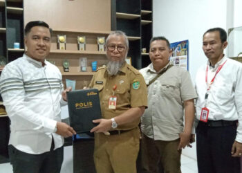 KEPALA DLH Tapin H Nordin berfoto bersama Kepala Cabang Asuransi BUMIDA Banjarmasin Syahrial Rifani usai penyerahan dokumen kerja sama, Senin (6/5).