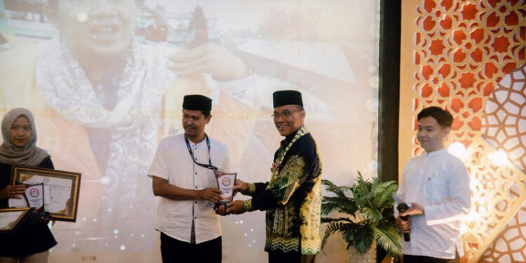 Staf Ahli Gubernur Bidang Pemerintahan, Hukum dan Politik, Adi Santoso, SSos, MSi saat menyerahkan penghargaan pada Anugerah Syiar Ramadhan 2024, Lecture Theatre Gedung Kampus Baru Fisipol ULM Banjarmasin 