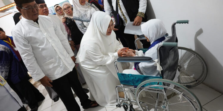 SAPA JEMAAH - Gubernur Kalimantan Selatan H Sahbirin Noor dan Ketua Tim Penggerak PKK Provinsi Kalsel Hj Raudatul Jannah atau Acil Odah menyapa calon jemaah haji lansia yang menggunakan kursi roda dari kloter 1 Embarkasi Banjarmasin.