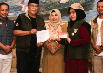 Gubernur Kalimantan Selatan, H Sahbirin Noor dan isteri, Hj Raudatul Jannah atau Acil Odah berfoto bersama petugas Coklit dan Pantarlih Martapura Timur, usai melaksanakan pencocokan data pemilih Pilkada 2024 