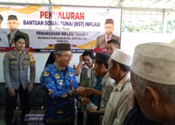 PJ Bupati Tapin M Syarifuddin saat penyerahan bantuan sosial tunai di Kelurahan Tambarangan, Kecamatan Tapin Selatan.