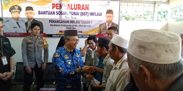 PJ Bupati Tapin M Syarifuddin saat penyerahan bantuan sosial tunai di Kelurahan Tambarangan, Kecamatan Tapin Selatan.