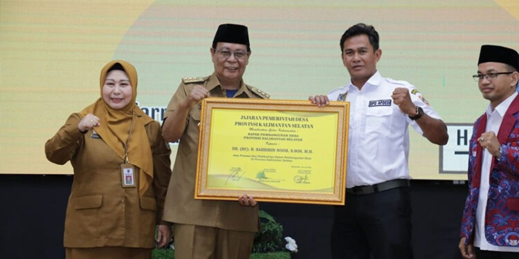 GUBERNUR Kalimantan Selatan H Sahbirin Noor didampingi Ketua Tim Penggerak PKK Kalsel, Hj Raudatul Jannah ketika menerima anugerah sebagai bapak pembangunan desa di Provinsi Kalsel.