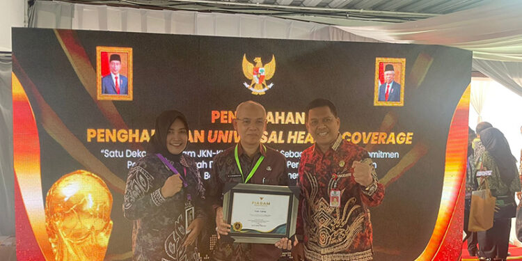SEKDA Tapin H Sufiansyah di dampingi Kadis Kesehatan H Alfian Yusuf saat menerima penghargaan UHC Kategori Madya dari Pemerintah Pusat, Kamis (8/8).