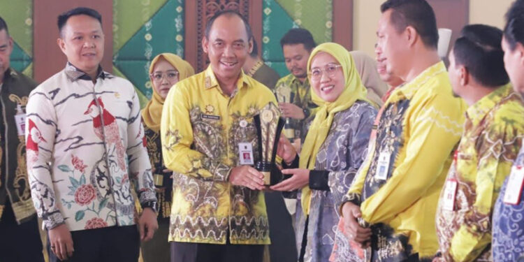 Staf Ahli Gubernur Bidang Pemerintahan, Hukum dan Politik, Adi Santoso saat menyerahkan penghargaan kepada Kepala Dinas Lingkungan Hidup Provinsi Kalsel, Hanifah Dwi Nirwana sebagai terbaik 1 Kategori Inovasi SKPD Provinsi Kalsel