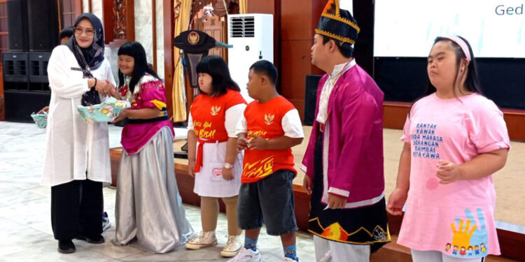 Staf Ahli Gubernur Bidang Kemasyarakatan dan SDM, Hj Husnul Khatimah saat memberikan hadiah kepada sejumlah anak penyandang Down Syndrome di Kalsel