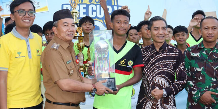 Pj Bupati Tapin M Syarifuddin MPd saat menyerahkan trophy juara Turnamen Sepakbola BRE CUP VI.