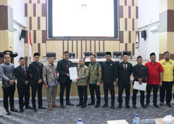 KETUA KPU Tapin Fakhrian Noor saat menyerahkan SK penetapan kepada H Yamani dan H Juanda.