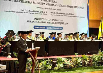 Staf Ahli Gubernur Bidang Pemerintahan, Hukum dan Politik, Adi Santoso, SSos, MSi saat membacakan sambutan tertulis Gubernur Kalsel pada pengukuhan dua orang Guru Besar di Uniska Banjarmasin