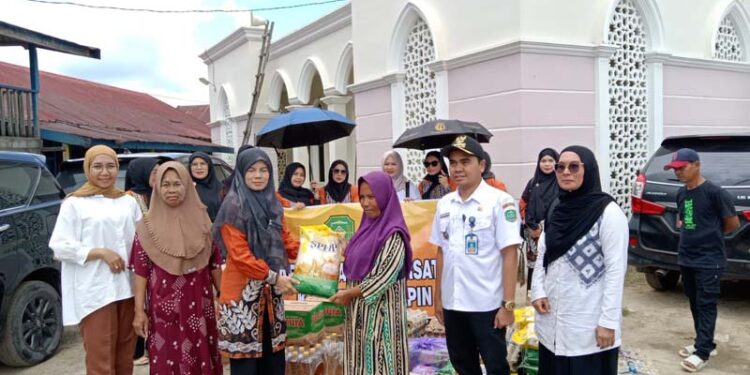 Ketua DWP Tapin Hj Mashuriyah dan jajaran saat menyerahkan bantuan sembako ramadhan untuk korban terdampak banjir di Kelurahan Raya Belanti, Kecamatan Binuang yang terjadi beberapa waktu lalu.