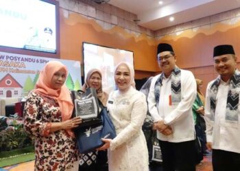 Ketua Tim Pembina Posyandu Provinsi Kalimantan Selatan, Hj Fathul Jannah saat menyerahkan media edukasi Isi Piringku serta buku pengelolaan Posyandu bidang kesehatan kepada kader Posyandu dari 13 kabupaten/kota