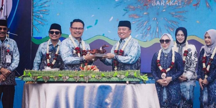 GUBERNUR Kalimantan Selatan H Muhidin saat menyerahkan itik panggang kepada Penjabat (Pj) Walikota Banjarbaru H Subhan Nor Yaumil pada puncak peringatan Hari Jadi ke-26 Kota Banjarbaru.