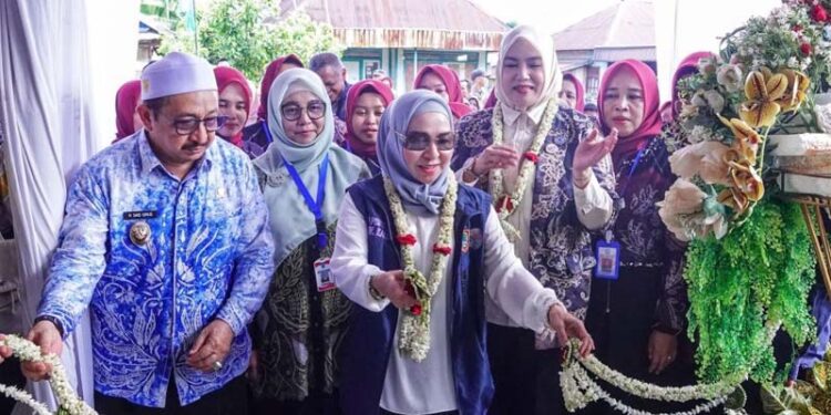 Ketua Tim Pembina (TP) Posyandu Provinsi Kalimantan Selatan, Hj Fathul Jannah Muhidin saat memotong untaian melati pada Posyandu Jati 2, Desa Pasar Jati, Kabupaten Banjar