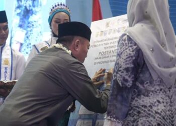 Gubernur Kalimantan Selatan, H Muhidin saat menandatangani komitmen bersama untuk menerapkan 6 standar pelayanan minimal (SPM) di Kalsel, disaksikan Ketua Tim Pembina Posyandu Provinsi Kalsel, Hj Fathul Jannah